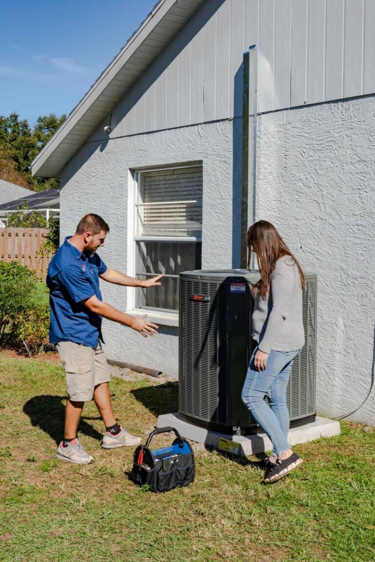 An AC technician explains the the HVAC tune up processs to a VIP HVAC Maintenence Membership plan member