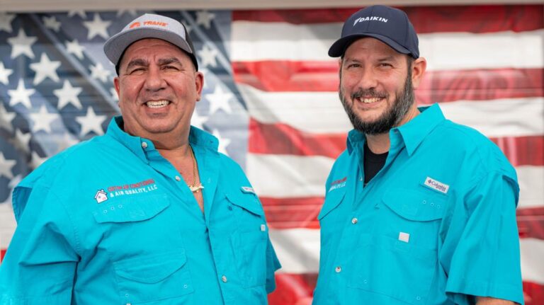 Custom Air Conditioning & Air Quality owner Patrick and technician Aaron pose in front of the American flag