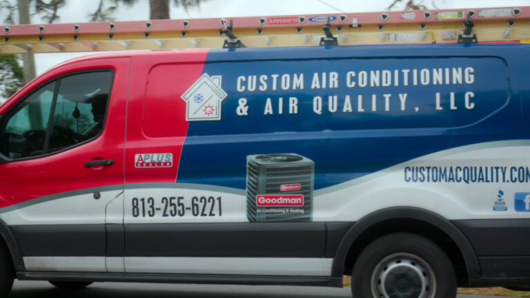 Custom air conditioning and air quality service truck driving through a residential neighborhood