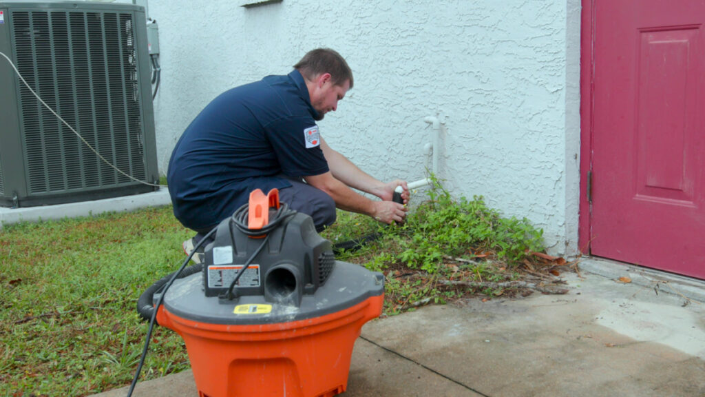 Custom air conditioning and air quality technician inspecting outdoor HVAC components